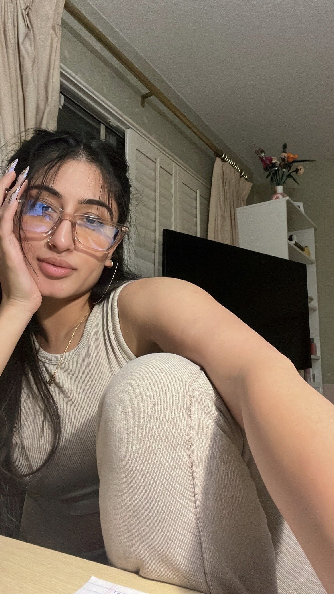 Isha Bhatt resting her chin on her hand, wearing glasses